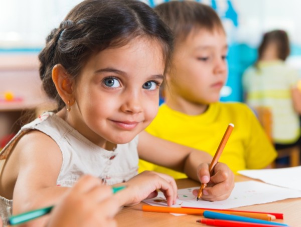 Group of cute little prescool kids drawing with colorful pencils